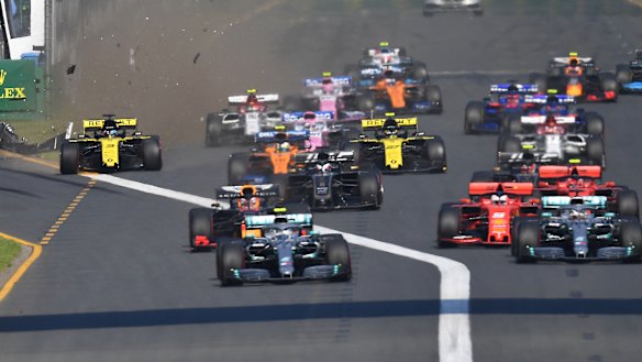Forced wide: Daniel Ricciardo raises a cloud of detritus and dust on the far left of the pack after impact with turn one obstacle.