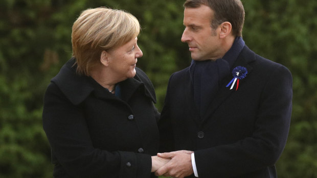French President Emmanuel Macron and German Chancellor Angela Merkel hold hands.