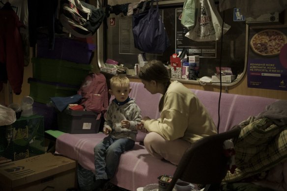 People sit inside a subway car parked in a station being used as a bomb shelter, as Russian attacks continue in Kharkiv, Ukraine.