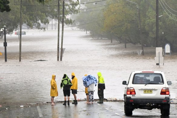 Residents inspect a flooded road in Lismore on Wednesday morning.