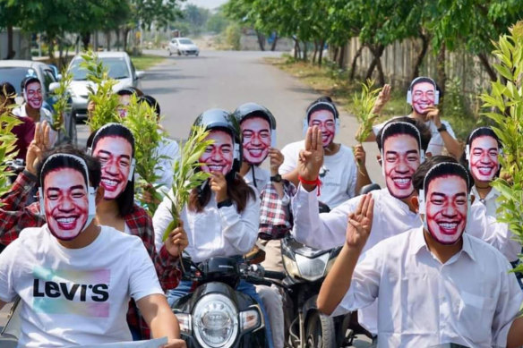 Supporters of the Myanmar alternative “national unit government” pose with masks of its spokesman, Dr Sasa.  