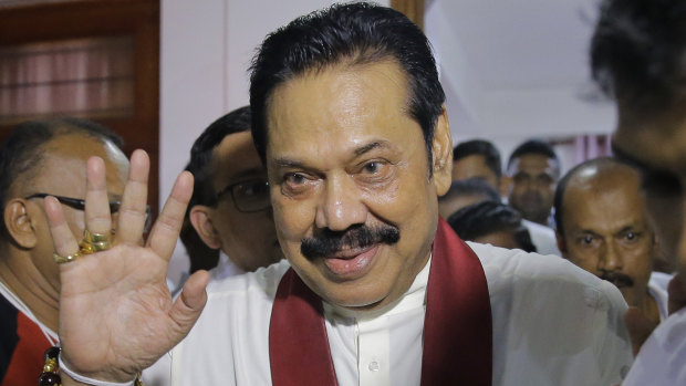 Newly appointed Sri Lankan Prime Minister Mahinda Rajapaksa leaves a Buddhist temple after meeting his supporters in Colombo.