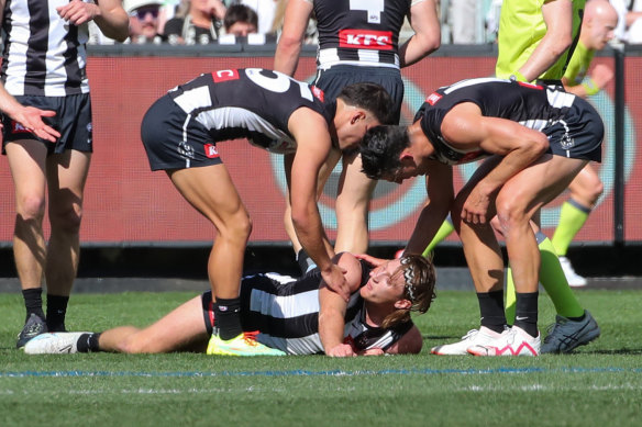 Teammates check on Nathan Murphy before he was subbed off.