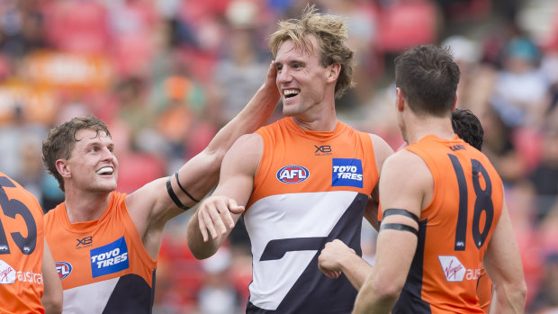 On the board: Teammates celebrate with Lachie Keeffe after kicking a goal against Essendon last weekend.