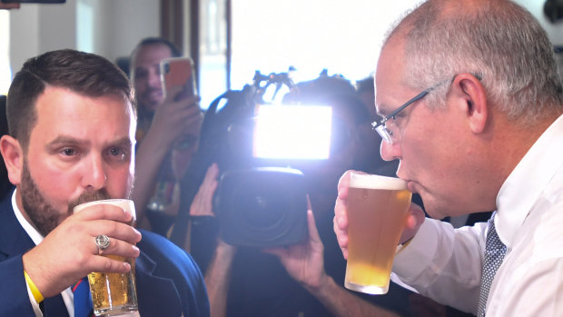 Scott Morrison sips his beer alongside the Liberal candidate for Herbert, Phillip Thompson, on Anzac Day.