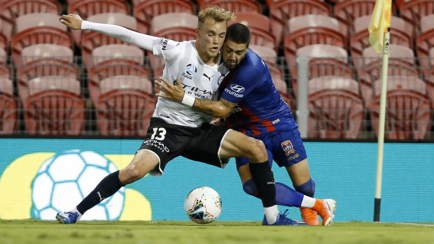 Dimi Petratos of the Jets contests the ball with Nathaniel Atkinson of Melbourne City.