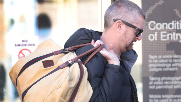 Glenn Hartland carries a bag as he arrives at the Melbourne County Court.
