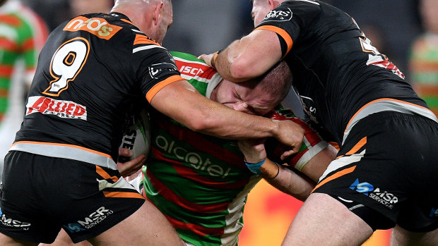 Running battle: Burgess is tackled by Farah and Matt Eisenhuth. The Tigers veteran revealed that Burgess had apologised at the end of the match.