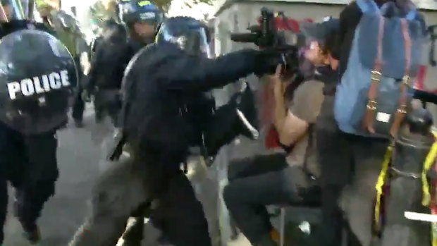Footage shows Channel Seven cameraman Tim Myers being punched by a police officer while covering protests outside the White House.