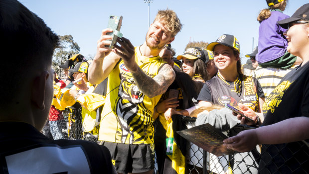 Tigers defender Nathan Broad poses for a selfie with fans at training on Friday. 
