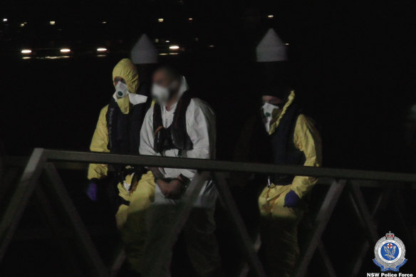 The men under police guard after their arrest.