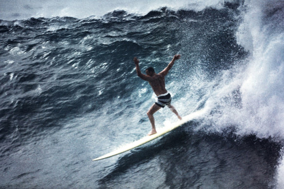 Noll surfing Waimea in his black striped boardshorts.