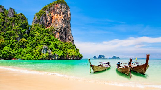 Traditional boats, beaches and a limestone cliff for a quintessential tropical Thai setting.