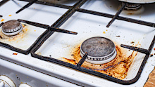 a very dirty gas stove with grease and carbon deposits due to long-term use