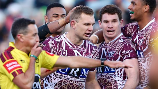 Manly congratulate Tom Trbojevic after one of his three tries.