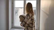 The girl holds a cozy soft blanket in her hands. Warm blanket in the hands of a woman close-up. Winter mood and home textiles