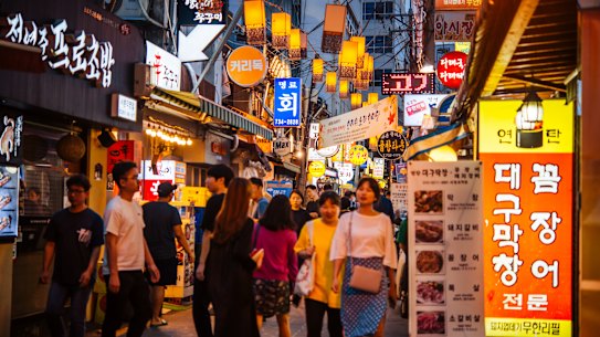 Bustling street scene at Sejong Village Food Street in Seoul.
