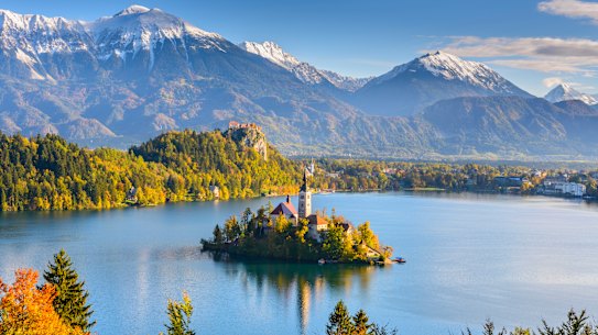 The Julian Alps rise up behind Bled Island in Slovenia.