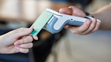 Closeup of a bankcard tapping a wireless POS reader for secure cashless transaction, ideal for fintech, retail and small business promos.
