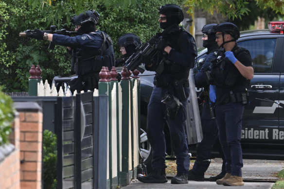 An armed officer aims their weapon at a Reservoir home where a man was killed on Wednesday morning.