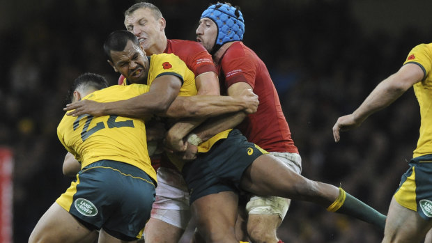 Crunched: Kurtley Beale in the thick of the action against Wales in Cardiff. 