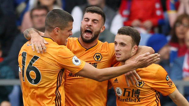 Patrick Cutrone of Wolverhampton Wanderers celebrates with teammates Diogo Jota and Conor Coady after scoring the equaliser against Palace.