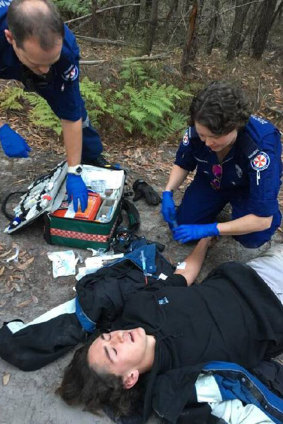 Paramedics attend to Darcy McKay after his bike crashed on a rutted dirt track in Pambula Beach. He used Siri to call triple zero.