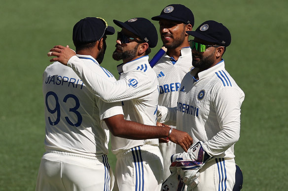 Virat Kohli (second from right) congratulates Jasprit Bumrah on India’s win.
