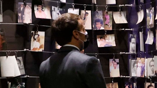 French President Emmanuel Macron looks at the images of genocide victims on display during his visit to the Kigali Genocide Memorial, where some 250,000 victims of the Rwanda massacres are buried, in Kigali.
