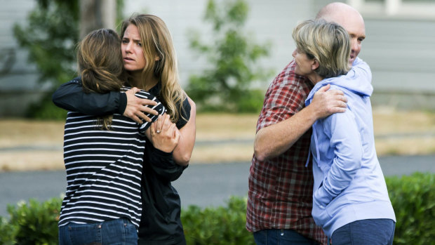 Friends of Richard Russell  hug in disbelief on Saturday.