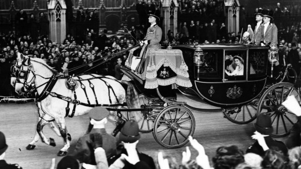 The married couple wave from a carriage on their way back to Buckingham Palace after the ceremony.