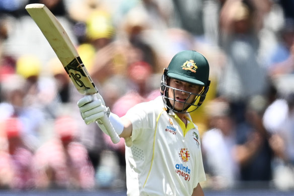 Marcus Harris raises his bat after passing 50. 