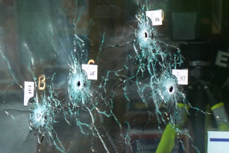 Bullet holes are seen in a window as an investigator works at the scene of a fatal shooting at a supermarket in Buffalo.