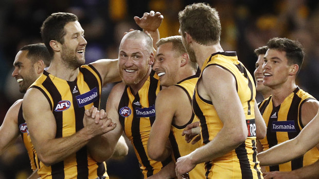Rough and ready: Teammates gather to congratulate retiring Hawthorn champion Jarryd Roughead (fourth from left) after he added another goal to his tally against the Suns at Marvel Stadium on Sunday.