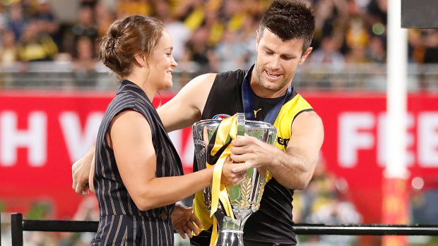 Ash Barty presents the 2020 AFL premiership cup to Trent Cotchin.