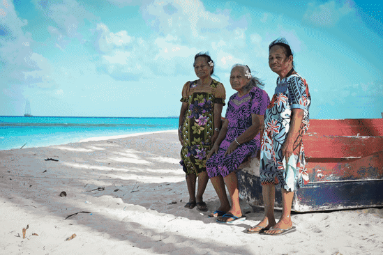   Castle Bravo survivors (from left) Susan Ned, Kathy Joel and Mina Titus on a beach on Mejatto Island in the Marshall Islands. Greenpeace flagship, the Rainbow Warrior III, is in the background.