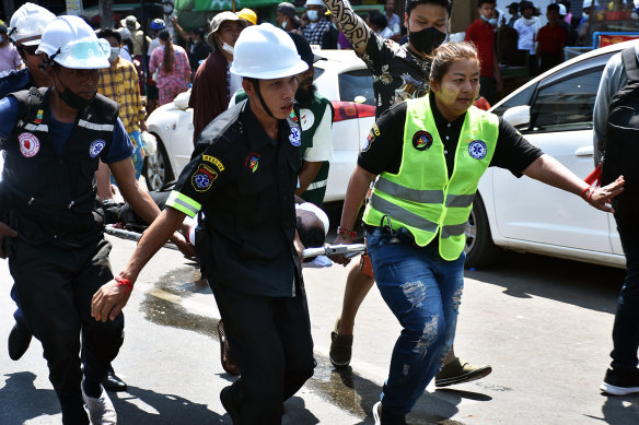 Askeri darbeye karşı ilk protestoların ortasında yaralı bir gösterici götürüldü.