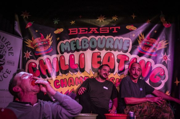 Participants Sina Sucuka and Ritchie Stalls watch on in pain as the Oceania Champion Chilli eater Greg Barlow downs another chilli.