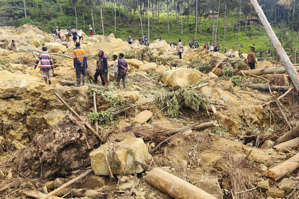 Villagers search landslide debris in the village of Yambali, PNG.