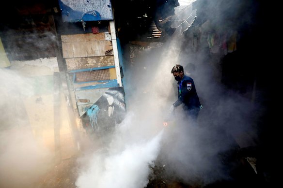 A worker fumigates a slum area to prevent dengue fever outbreak in Jakarta, Indonesia, earlier this year.