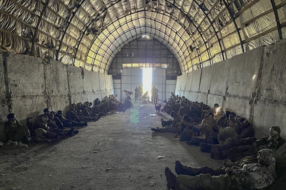 In this photo provided by the Ukrainian Security Service Press Office, more than 100 captured Russian prisoners wait in a shelter in Kursk region, Russia.