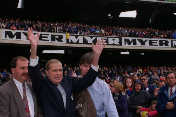 Whitten, supported by his son (left) and Danny Frawley (right), waves to the MCG crowd at the 1995 State of Origin clash.