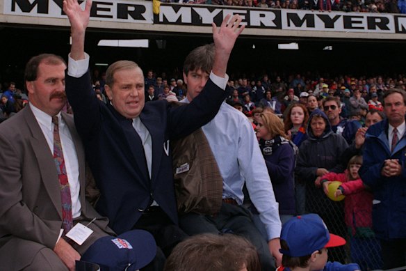 Whitten, supported by son Ted jnr (left) and Danny Frawley (right), waves to the MCG crowd at the 1995 State of Origin clash.