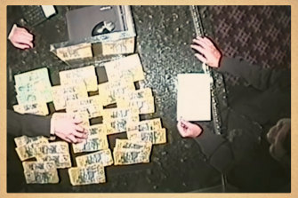 Roy Moo, right, on surveillance footage piling cash onto the counter at Crown casino in Melbourne. This recording was presented in court.