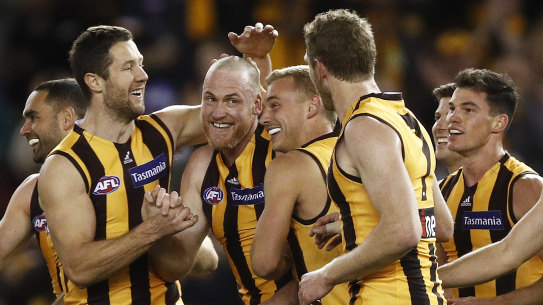 Rough and ready: Teammates gather to congratulate retiring Hawthorn champion Jarryd Roughead (fourth from left) after he added another goal to his tally against the Suns at Marvel Stadium on Sunday.