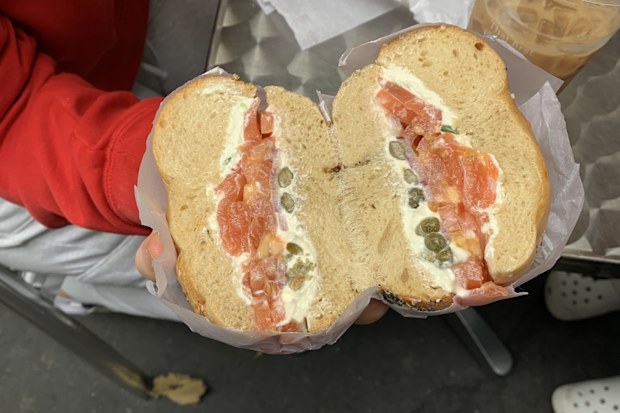 The cross section of a bagel containing salmon, cream cheese, and capers