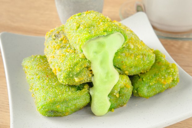 Sweet Crispy pandan Risoles with Melted Creamy Filling and Cup of Tea on Wooden Background