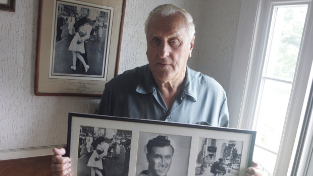 George Mendonsa poses for a photo in 2009 with a copy of the iconic 1945 photo.