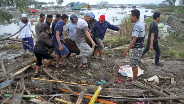 Residents carry the body of a tsunami victim in Palu, Central Sulawesi.