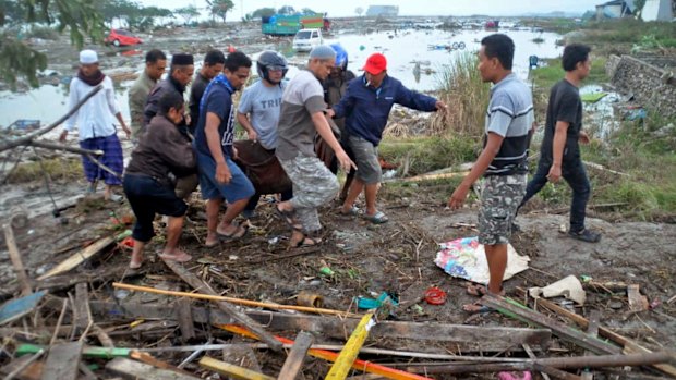 Residents carry the body of a tsunami victim in Palu, Central Sulawesi.